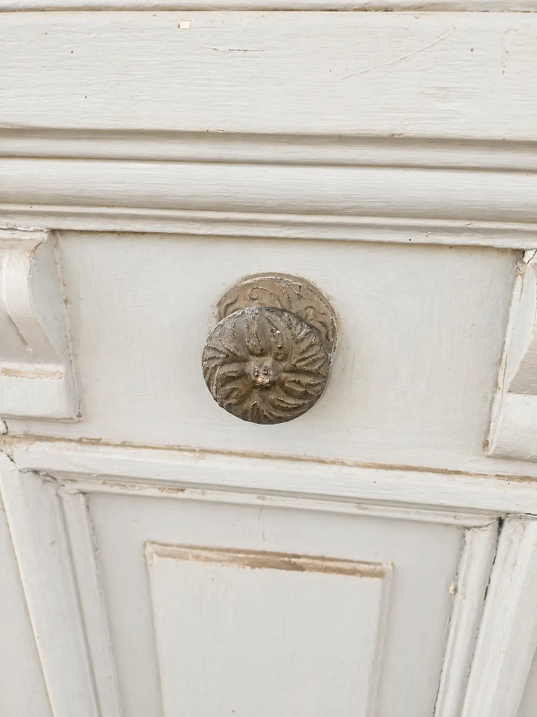 Detalle del manillón de bronce de una puerta antigua con molduras