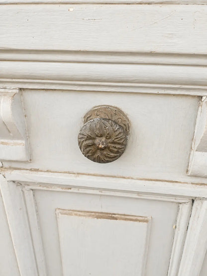 Detalle del manillón de bronce de una puerta antigua con molduras